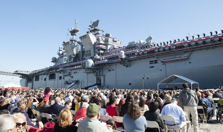group of people gathered in front of military ship